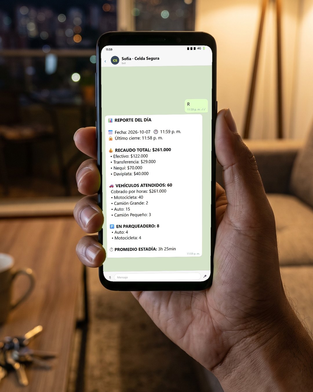 Celular en la sala de una casa, de noche: el dueño le escribió R a Sofía y ella responde con el reporte del día: recaudo total $261.000 por medio de pago, 60 vehículos atendidos y 8 en el parqueadero.